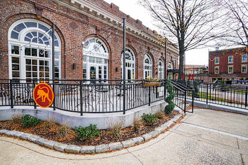 A brick building with a sign that says "Upstairs money" on it.