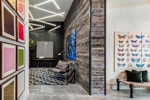 A room with a grey carpet and a wooden wall.
