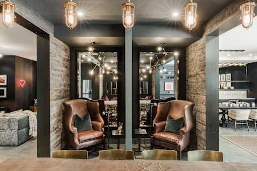 Two brown chairs are placed in front of a wall with a red heart on it.