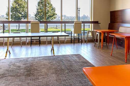 A conference room with a long table and chairs with a view of the city outside the window.