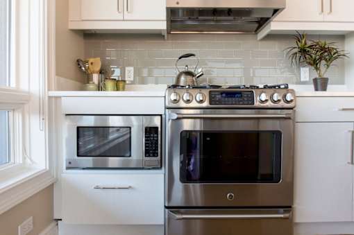 A modern kitchen with a stainless steel oven and microwave.