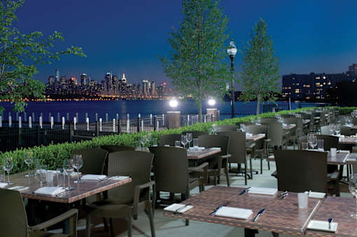 A restaurant with a view of the city skyline at night.