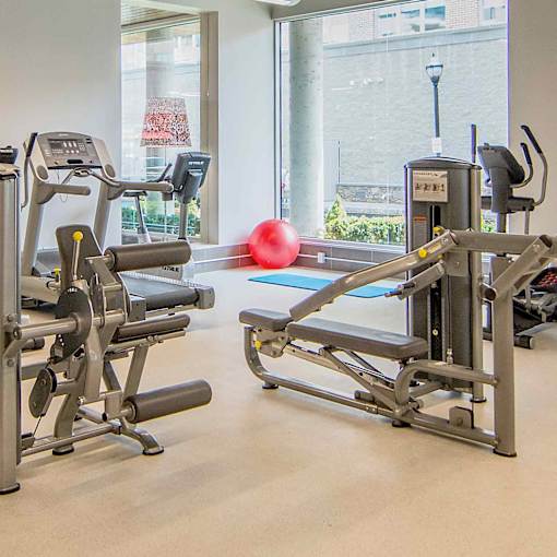 A gym with a red ball and a treadmill.