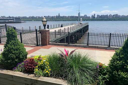 A view of a pier with a lamp post and a fence.