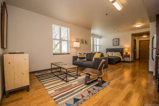 Portland OR Apartments - Corbett Heights Living Room in Our Studio Apartments With Cozy Decor and Hardwood-Style Floors