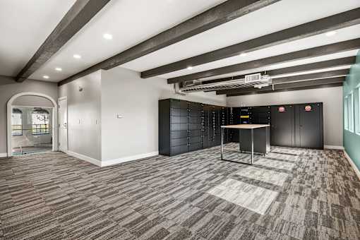 A room with a carpeted floor and a table with a black cabinet in the background.