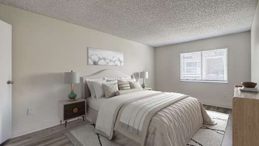 Aurora, CO Apartments – Ivy Crossing – A bedroom with a large bed and a nightstand with a lamp.