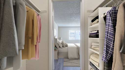 A bedroom with a bed and a closet with clothes.