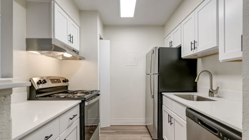 A kitchen with white cabinets and black appliances.