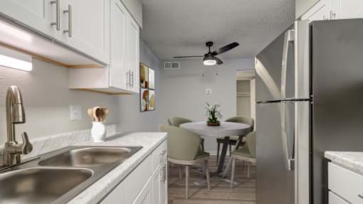 A kitchen with a table and chairs in the middle.