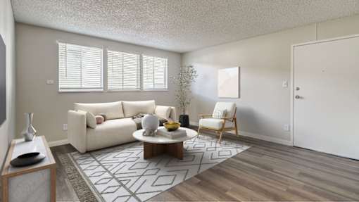 A living room with a white couch, a coffee table, and a chair.