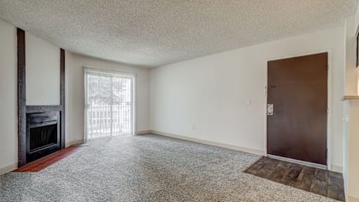 Aurora, CO Apartments – Ivy Crossing – A room with a fireplace and a door.