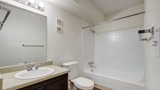 A white bathroom with a sink, toilet, and bathtub.