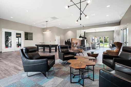 A modern living room with black leather furniture and a wooden coffee table.
