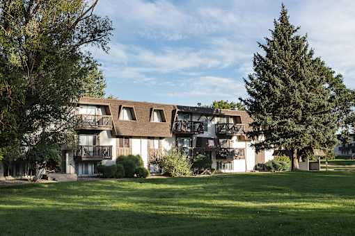 A large building with a balcony and a tree in front of it.