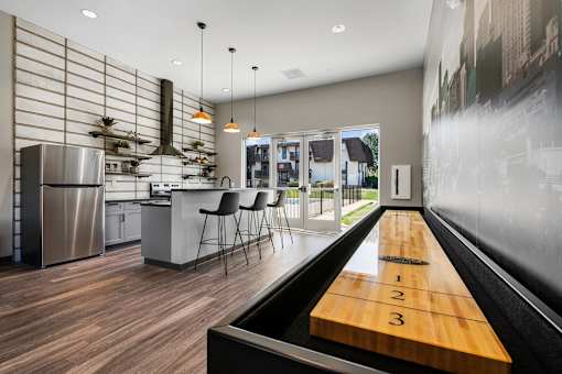 A modern kitchen with a shuffleboard table in the middle.