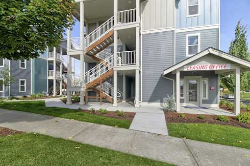 A leasing office is located on the ground floor of a two-story apartment building.