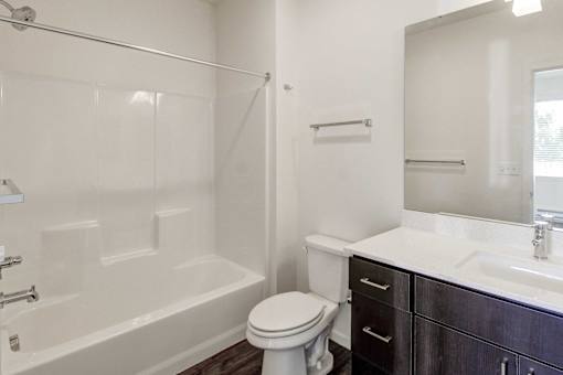 A white bathroom with a toilet, sink, and bathtub.