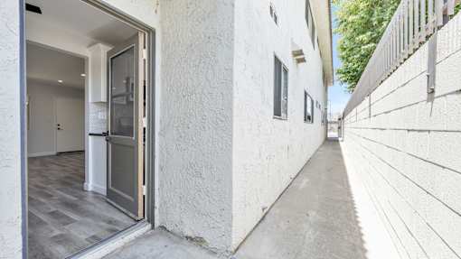 A white building with a grey door and a grey floor.