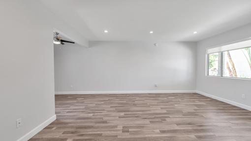 A room with wooden flooring and white walls.