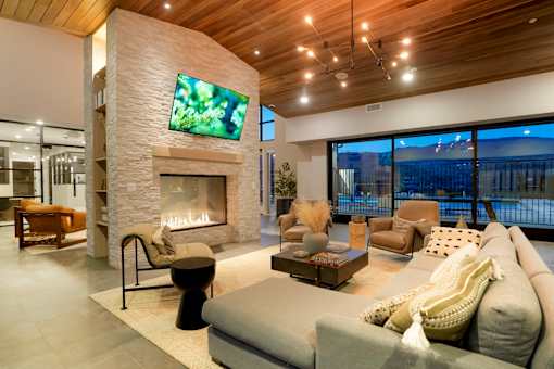 A modern living room with a stone fireplace and a flat screen TV mounted on the wall.
