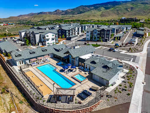 A large swimming pool surrounded by houses and a fence.