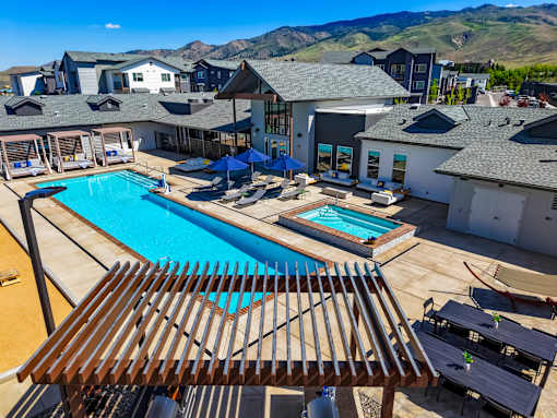 A large outdoor swimming pool with a wooden deck in front.