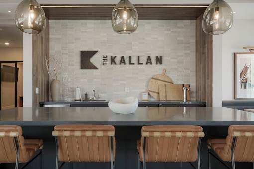 A modern kitchen with a large island and chairs.