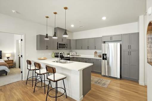 A modern kitchen with a white island and stainless steel appliances.