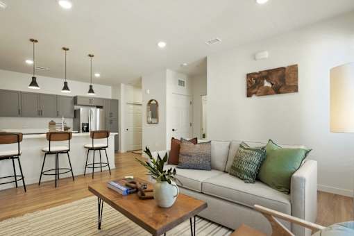 A modern living room with a white couch and a wooden coffee table.