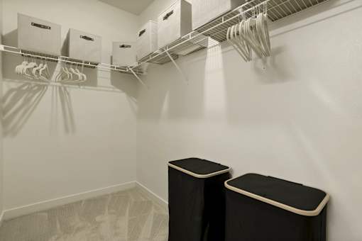 A laundry room with a clothes dryer and a clothes rack.