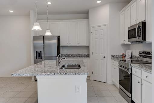A kitchen with white cabinets and appliances.