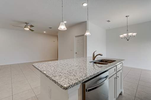 A kitchen with a granite countertop and a dishwasher.