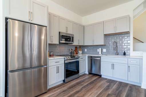 Luxury Atlanta, GA Homes – LaFrance Square – A kitchen with a stainless steel refrigerator and white cabinets.
