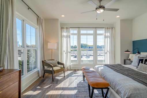 Pet-Friendly Homes In Edgewood, GA – LaFrance Square- A bedroom with a large bed, a chair, and a window with a view of the city.