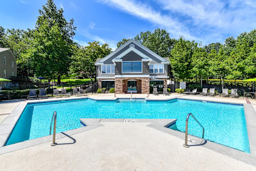 A large swimming pool in front of a house.