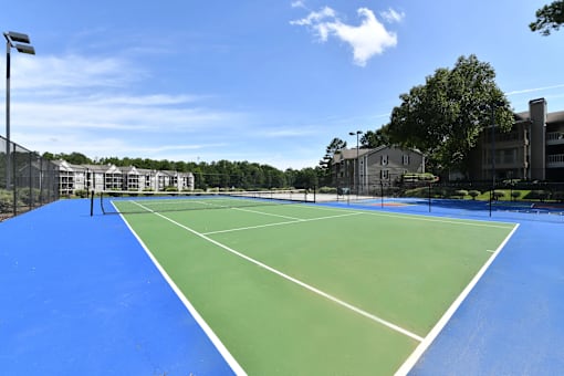A tennis court with a blue surface and white lines.