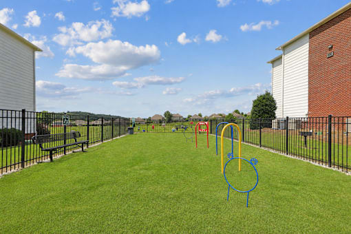 Pet-friendly bark park at Lancaster Place Apartments in Calera, Alabama with fenced play areas and agility equipment for resident pets.