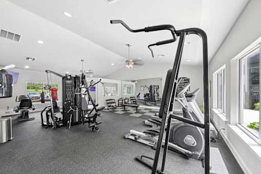 Modern fitness center at Lancaster Place Apartments in Calera, AL with strength training equipment and cardio machines for residents.