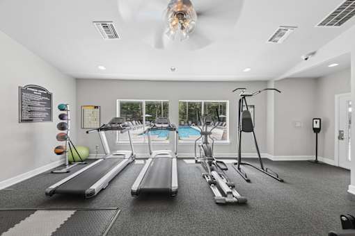Bright resident fitness center at Lancaster Place Apartments in Calera, Alabama featuring treadmills, weight equipment, and spacious workout areas.