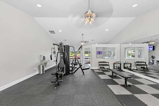 Fully equipped apartment fitness center at Lancaster Place Apartments in Calera, AL with free weights, cardio equipment, and natural light.