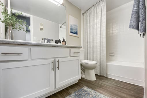 A white bathroom with a toilet, sink, and bathtub.