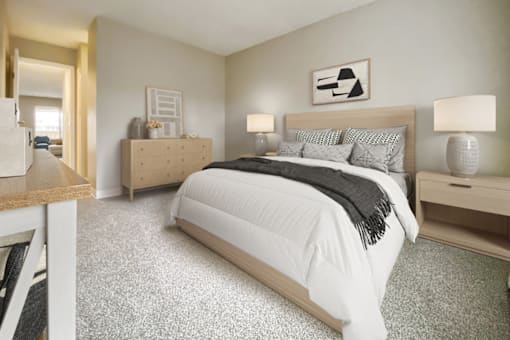 A bedroom with a large bed and a nightstand with a lamp.