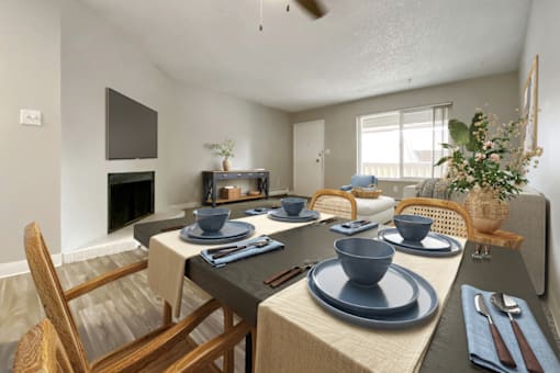 A dining table set with blue plates and cutlery.
