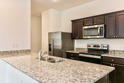 A kitchen with granite countertops and stainless steel appliances.