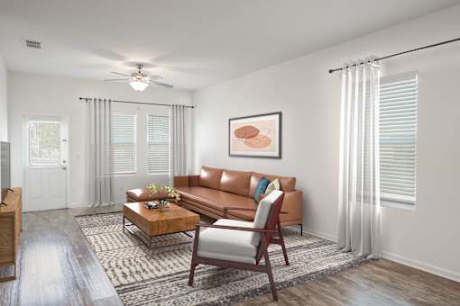 A living room with a brown couch, a coffee table, and a ceiling fan.