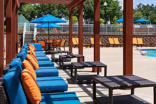 Poolside lounge seating with shaded pergola in Stockbridge GA apartment community