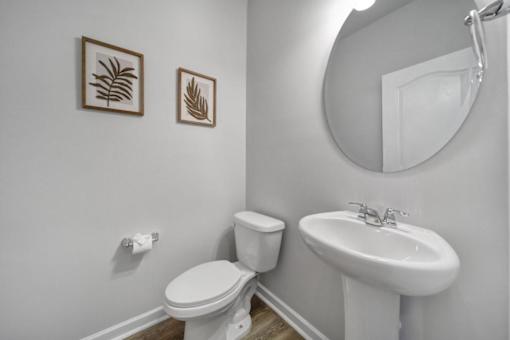 Modern bathroom with mirror, toilet, and sink in Indian Trail townhome