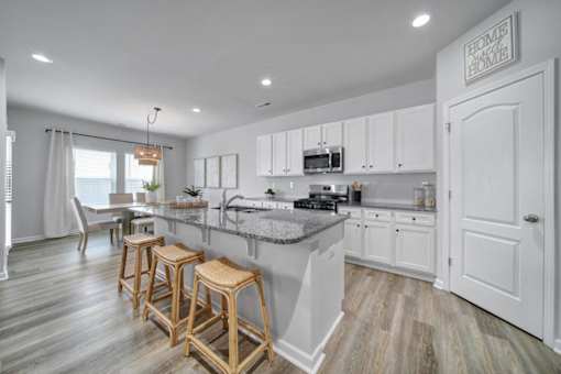 Spacious kitchen with island, stainless steel appliances, and granite countertops in Indian Trail, NC townhome