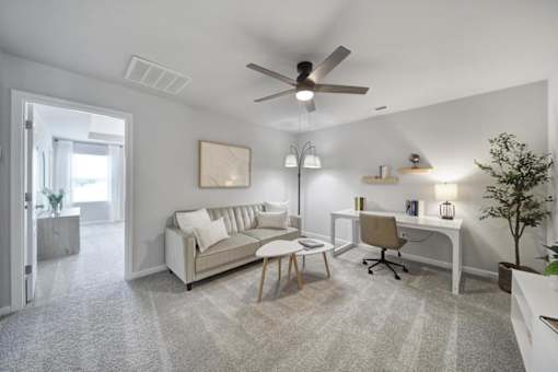 Spacious living area with couch, chair, desk, and vinyl plank flooring in Indian Trail townhome